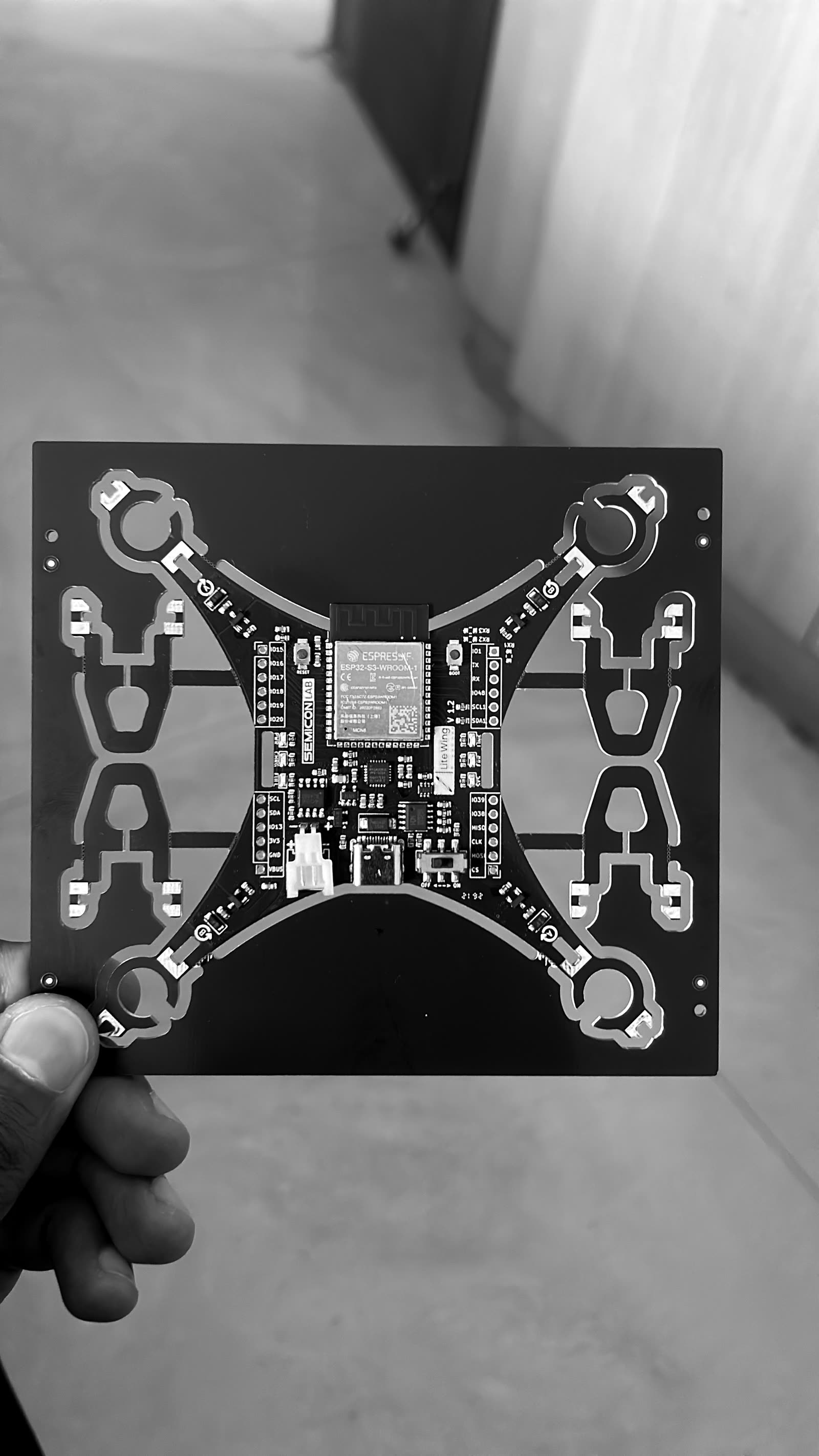 A custom ESP32-S3 quadcopter flight-controller board held in one hand