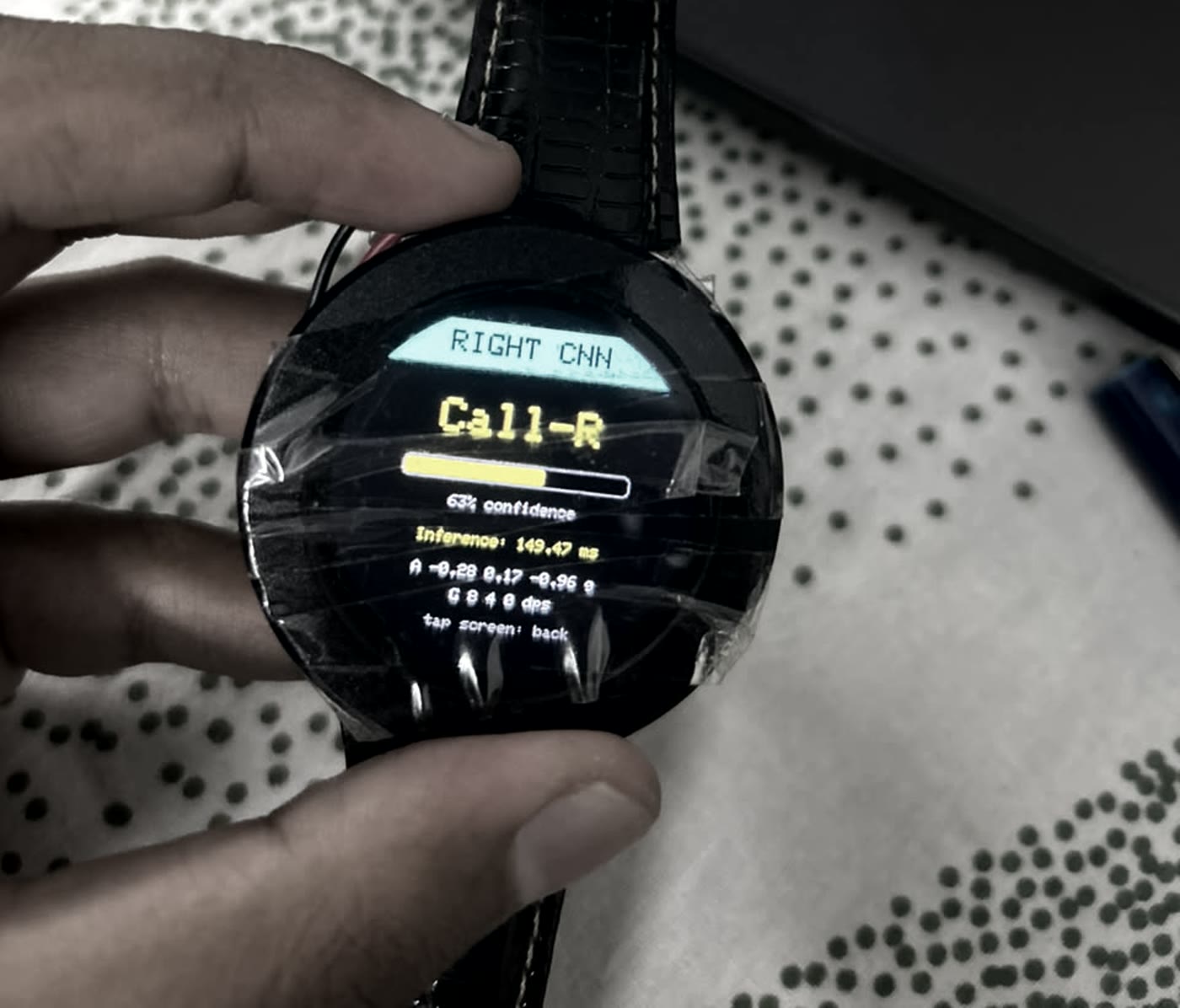 An ESP32-S3 watch running a quantised CNN on live IMU data, showing the prediction, confidence and inference time