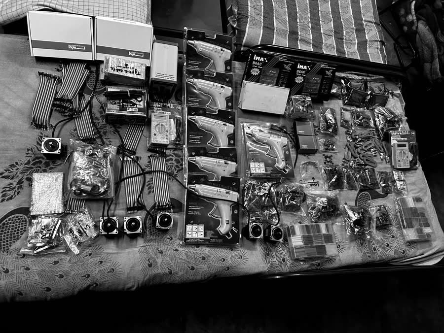 Workshop components laid out and counted: jumper wires, motors, sensors, glue guns and chargers